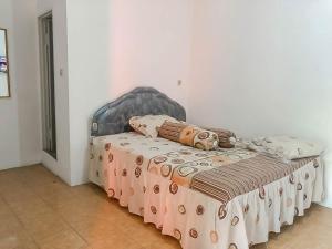 Postel nebo postele na pokoji v ubytování Rumah Panggung Guest House Syariah Mitra RedDoorz