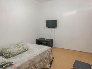 a bedroom with a bed and a tv on the wall at Rumah Panggung Guest House Syariah Mitra RedDoorz in Cirebon