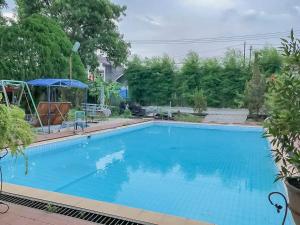 a large blue swimming pool in a yard at Rumah Panggung Guest House Syariah Mitra RedDoorz in Cirebon