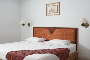 sypialnia z łóżkiem i 2 lampkami na ścianie w obiekcie Rudang Hotel & Resort Berastagi w mieście Berastagi +16 zdjęć