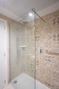 W łazience znajduje się prysznic ze szklanymi drzwiami. w obiekcie Hotel Colón w mieście Benidorm