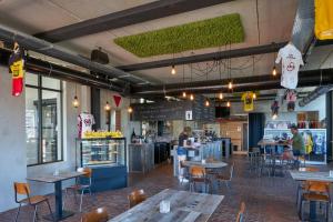 a restaurant with tables and chairs and a counter at Café Coureur Borgloon in Borgloon
