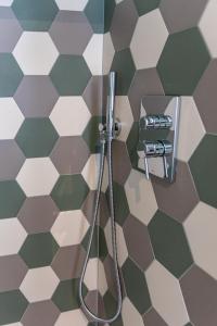 a shower in a bathroom with green and white tiles at IL TRENO DEI SOGNI BED & RELAIS in Conselve