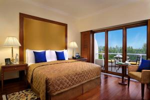 a hotel room with a bed and a balcony at The Oberoi Bengaluru in Bengaluru