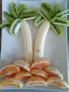 a plate with bananas and oranges and kiwi fruit at B&B Alfio Tomaselli in Nicolosi