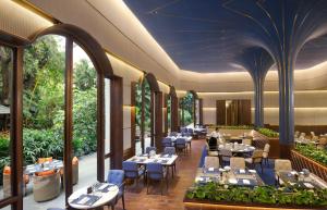 un restaurante con mesas y sillas en The Oberoi Bengaluru en Bangalore