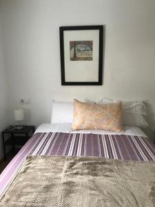 1 dormitorio con 1 cama y una foto en la pared en Polvorín, en Ourense