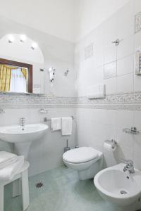 bagno bianco con lavandino e servizi igienici di Residenza d'Epoca San Cassiano a Venezia