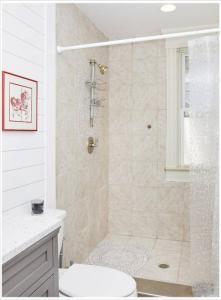a white bathroom with a shower and a toilet at Heart of Highlands 3BR Loft in Louisville