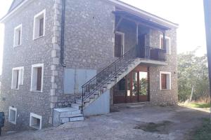 um edifício de tijolos com uma escada ao lado em Efis house em Kalívia