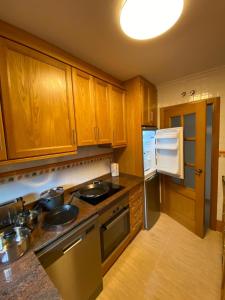 a kitchen with wooden cabinets and a stove top oven at S&H La Malcriada in San Juan de los Terreros