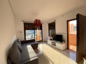 a living room with a couch and a television at S&H La Malcriada in San Juan de los Terreros