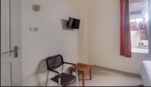 une chambre avec une chaise, une table et une fenêtre dans l'établissement RedDoorz @ Wanea Area Manado, à Manado