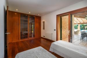 a bedroom with two beds and a sliding glass door at Villa Les Oliveres Antonia By SunVillas Mallorca in El Port +24 photos