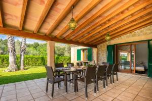 an outdoor dining room with a table and chairs at Villa Les Oliveres Antonia By SunVillas Mallorca in El Port