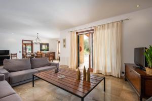 a living room with a couch and a coffee table at Villa Les Oliveres Antonia By SunVillas Mallorca in El Port