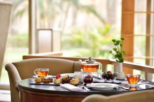 einen Tisch mit einem Tablett mit Essen und Tee darauf in der Unterkunft InterContinental Jeddah, an IHG Hotel in Dschidda