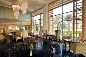 un restaurante con mesas, sillas y ventanas en InterContinental Jeddah, an IHG Hotel en Yeda
