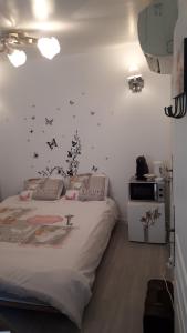 a bedroom with a bed with black butterflies on the wall at Mon Désir in Grand-Fort-Philippe