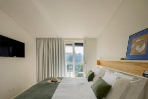 a bedroom with a bed and a large window at Casa do Fontanário Stay in Amarante
