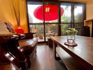 sala de estar con sofá, mesa y ventana en Guest House Oumi, en Kioto