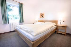 a large bed in a bedroom with a window at Ferienwohnung Königsleiten 3 Top 5 in Wald im Pinzgau