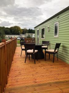 a deck with a table and chairs and a green trailer at Lakeside Holiday Rentals - Arizona in Great Billing