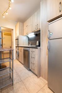cocina con armarios de madera y nevera de acero inoxidable en 1BD apartment in a calm area near the centre en Plovdiv