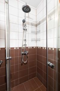 y baño con ducha y azulejos marrones. en 1BD apartment in a calm area near the centre en Plovdiv