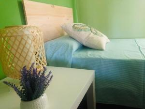 um quarto com uma cama com uma mesa e um vaso com flores em Hospedería de Juan em Fuentidueña de Tajo