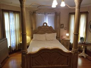 1 dormitorio con 1 cama grande de madera con columnas en Historic Victorian Inn en Sioux Falls