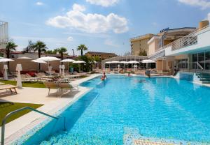 a swimming pool with chairs and umbrellas at a hotel at Palace Hotel Meggiorato in Abano Terme
