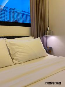 a bedroom with a white bed with a window at Monomer Hostel Bangkok in Bangkok