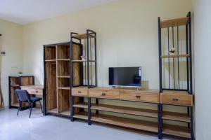 a room with a tv and a desk with a television at RedDoorz @ Jalan Bali Cilacap in Gumilir