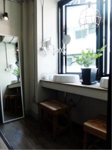 a bathroom with a sink and a window and a mirror at Monomer Hostel Bangkok in Bangkok