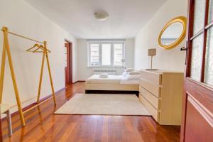 a bedroom with a bed and a dresser and a mirror at Krynica Apartamenty 100m Duży Apartament, Salon + 3 sypialnie przy Deptaku in Krynica Zdrój