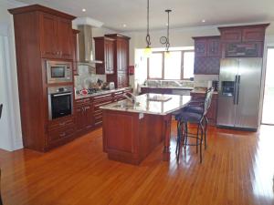 a kitchen with wooden cabinets and a island with a counter top at Sea View Holiday Home Sheeps HeadBantry in Bantry