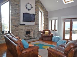 a living room with leather furniture and a fireplace at Sea View Holiday Home Sheeps HeadBantry in Bantry