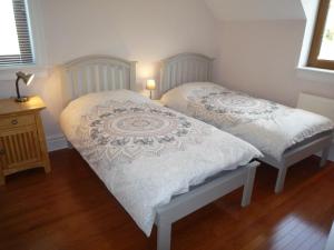 two twin beds in a room with wooden floors at Sea View Holiday Home Sheeps HeadBantry in Bantry