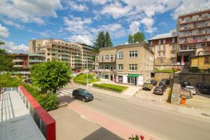 een straat met gebouwen en een auto op de weg bij Krynica Apartamenty 100m Duży Apartament, Salon + 3 sypialnie przy Deptaku in Krynica Zdrój