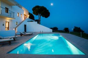 a swimming pool in front of a house at Skiathea Villas in Agia Paraskevi