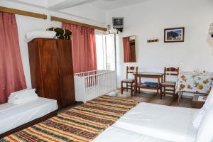 a bedroom with two beds and a crib and a table at Hotel Karpathos in Karpathos