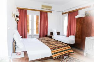 1 dormitorio con cama blanca y cortinas rojas en Hotel Karpathos, en Karpathos