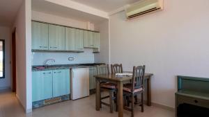 Apartamentos Paya II في إس بوخولس: مطبخ مع طاولة وكراسي ومغسلة