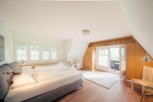 a bedroom with a large bed and a couch at "Reetland" - Haus Hartwig in Tating