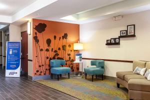 una sala de espera con 2 sillas azules y una pared con flores en Sleep Inn & Suites Hobbs, en Hobbs