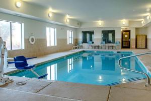 Sleep Inn & Suites في هوبز: مسبح كبير مع كرسي وطاولة