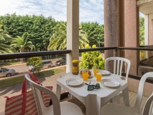 une table blanche et des chaises sur un balcon dans l'établissement Appartement plage de Trestraou 45m2, à Perros-Guirec