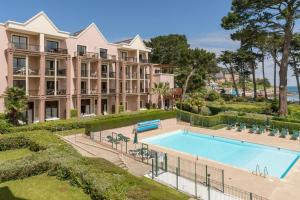 um edifício de apartamentos com uma piscina e um resort em Appartement plage de Trestraou 45m2 em Perros-Guirec