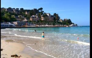 un niño parado en el agua en la playa en Appartement plage de Trestraou 45m2, en Perros-Guirec